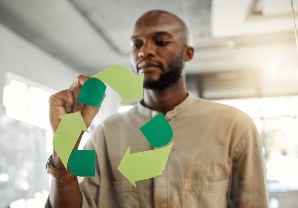 A businessman designing a sign for recycling awareness