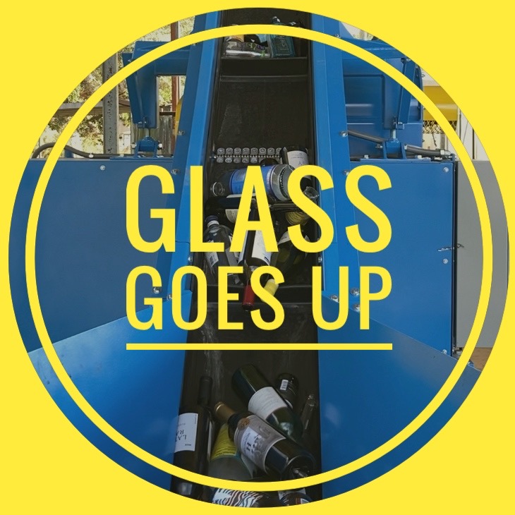 Glass bottles being fed into a recycling machine for processing into sand